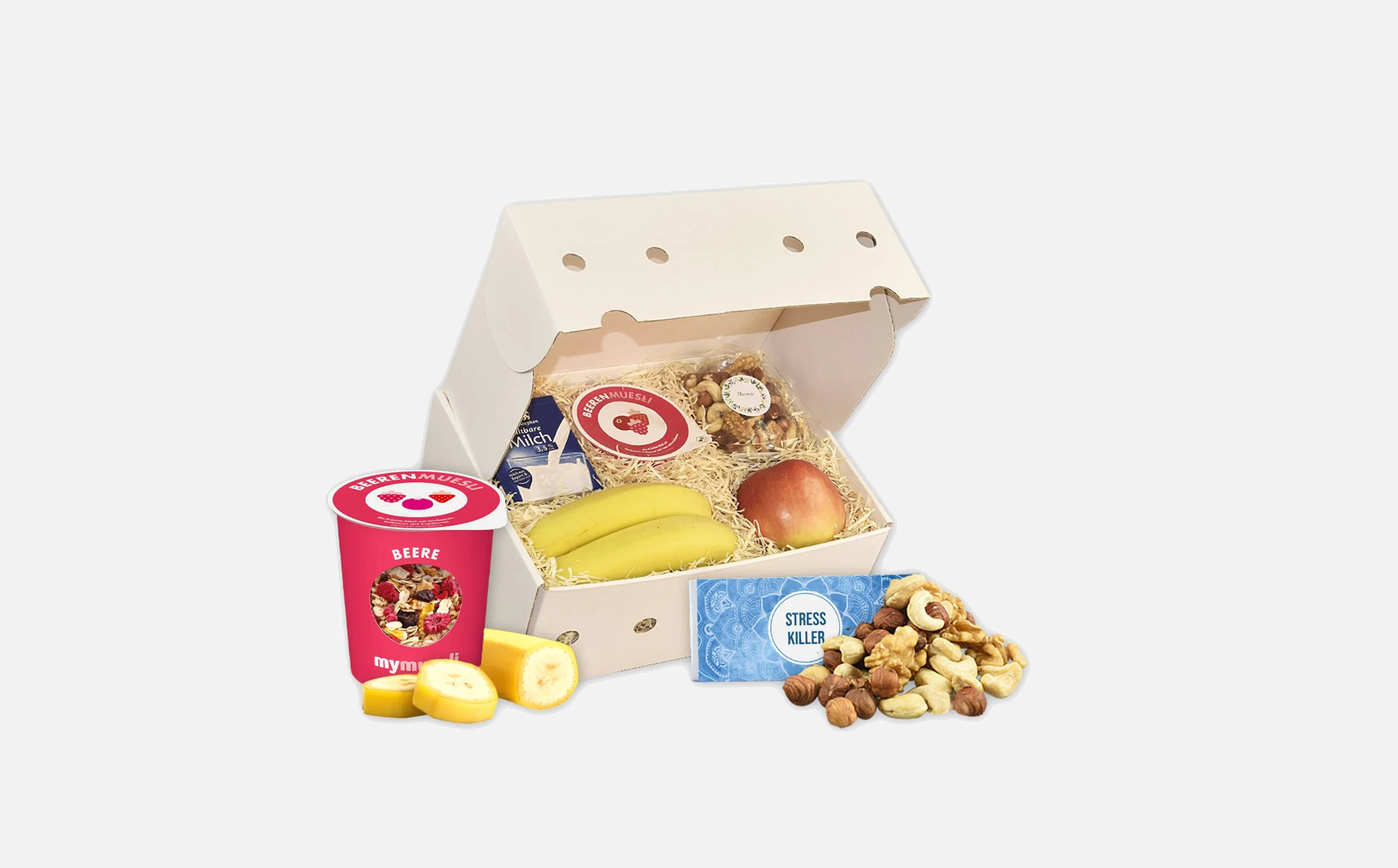 Obstbox mit Banane, Apfel, Müsli, Milch und Nüsse